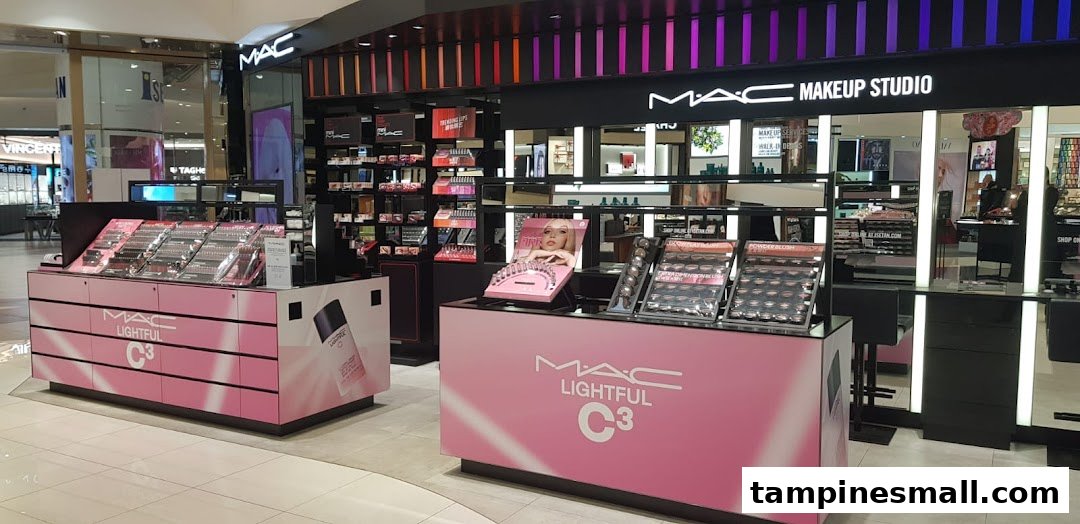 An interior view of MAC Cosmetics, showcasing makeup displays and product counters with pink branding.