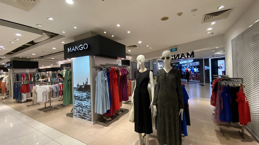 Interior view of MANGO fashion store showcasing diverse clothing collections and mannequins.