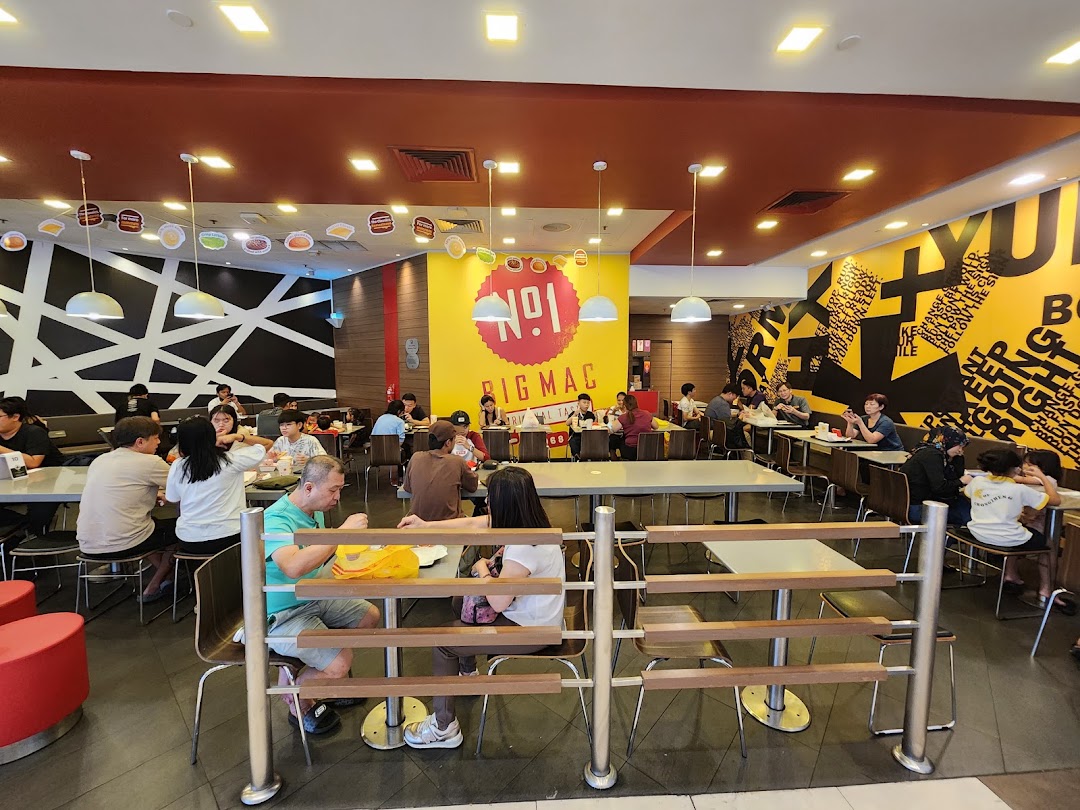 A bustling McDonald's dining area with customers enjoying meals at various tables.