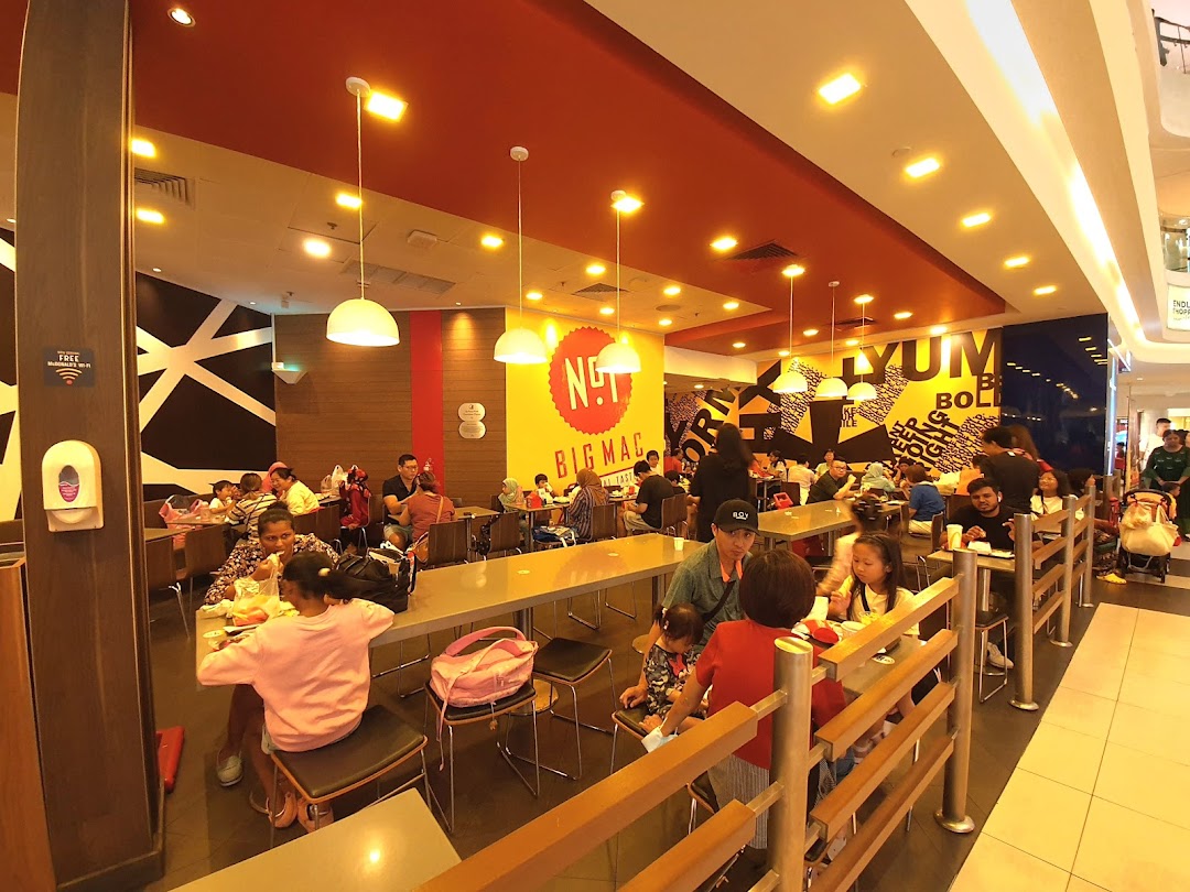 A bustling interior view of McDonalds Tampines Mall with many customers dining.