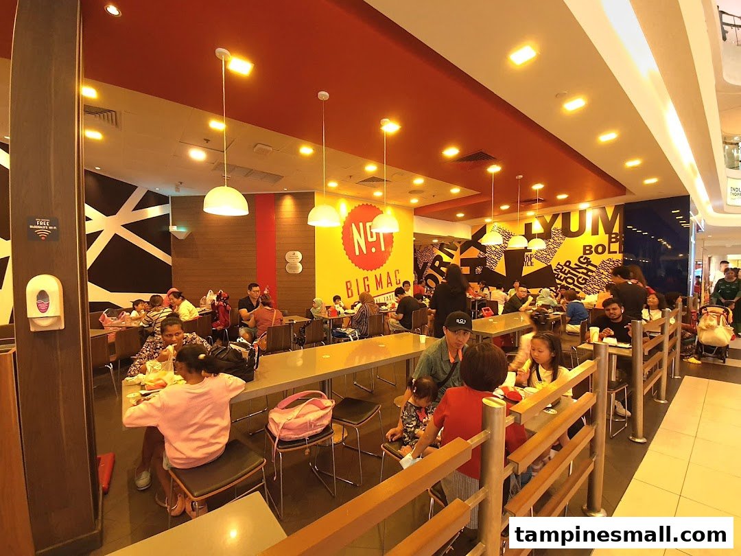 A bustling interior view of McDonalds Tampines Mall with many customers dining.