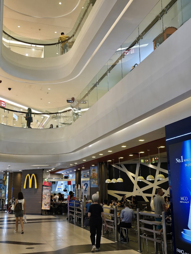 The bustling entrance and dining area of McDonald's Tampines Mall, seen from the mall's common area.