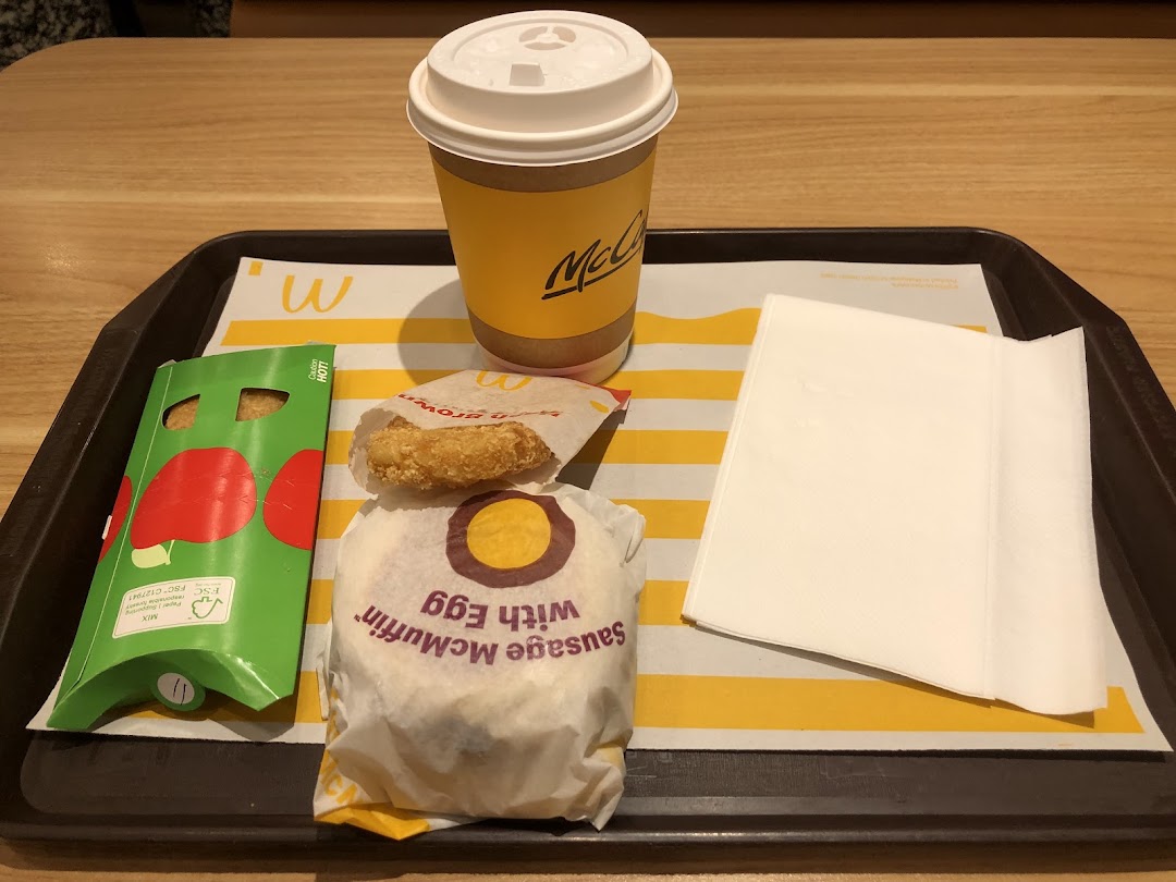 A McDonald's breakfast meal featuring a Sausage McMuffin with Egg, hash brown, and McCafé coffee.