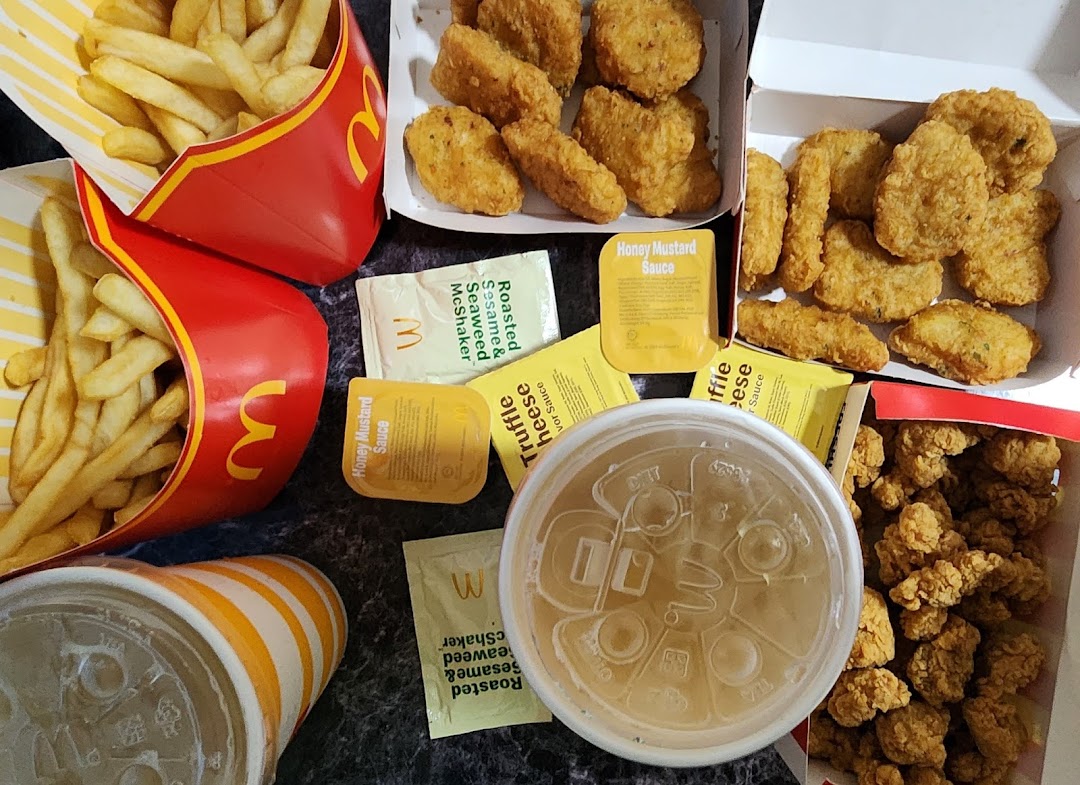 A delicious spread of McDonald's fries, chicken nuggets, and drinks with various sauces.