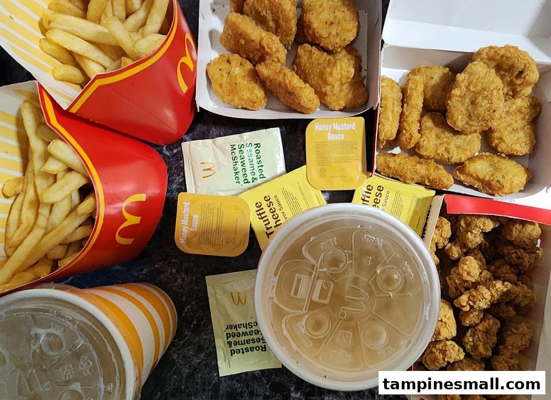 A delicious spread of McDonald's fries, chicken nuggets, and drinks with various sauces.