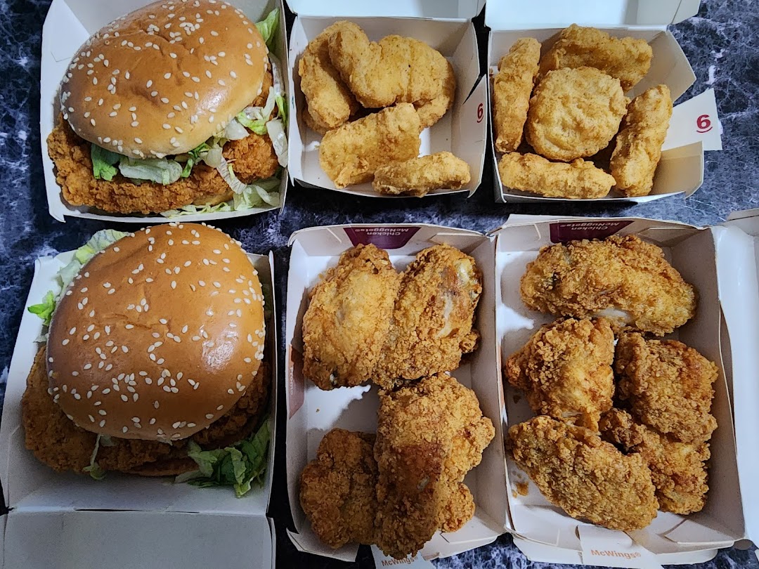 An assortment of McDonald's fried chicken, including burgers, nuggets, and chicken pieces.