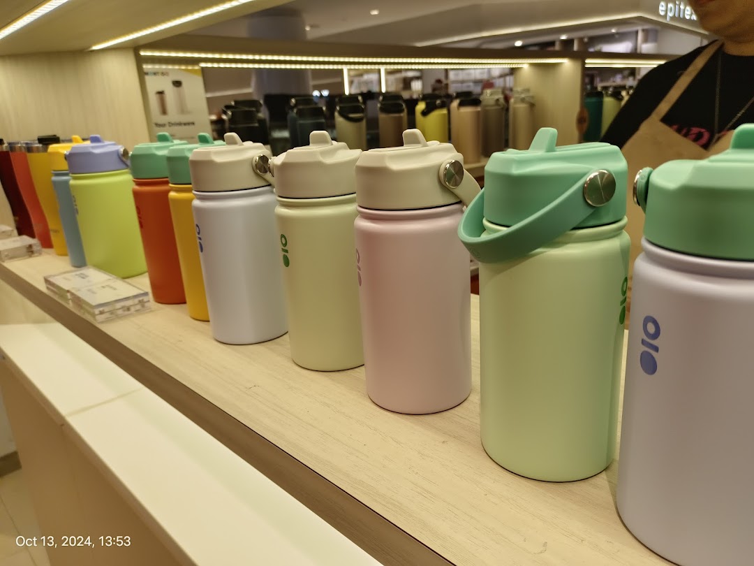 A vibrant display of colorful Montigo water bottles on a wooden shelf.