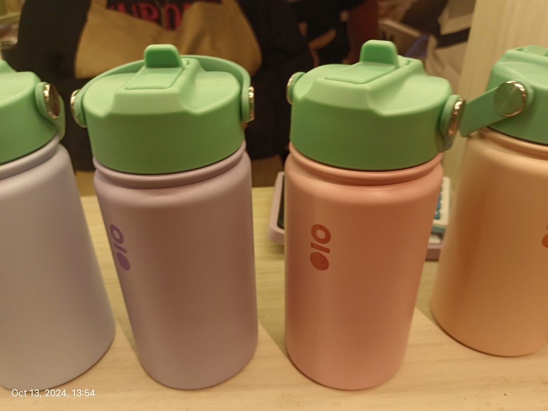 A close-up of colorful Montigo water bottles with green lids on display.