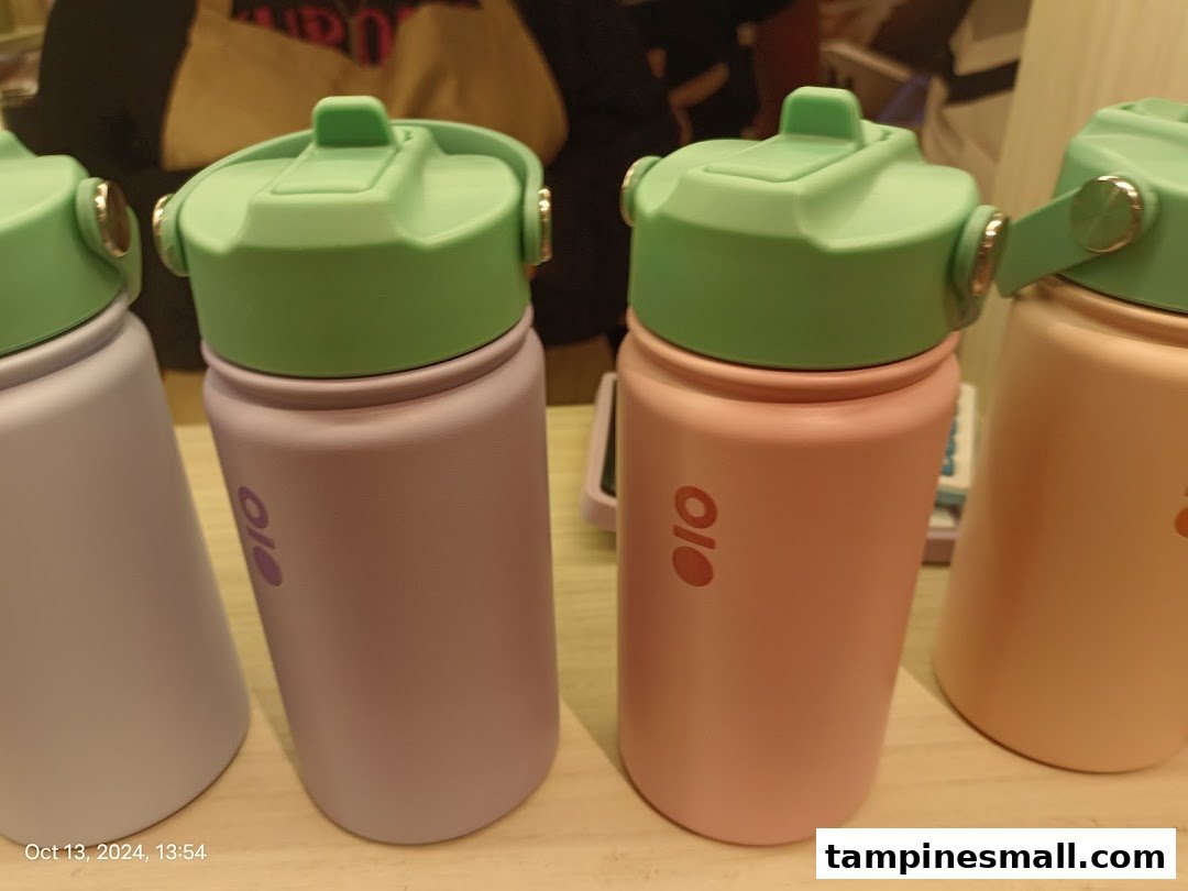 A close-up of colorful Montigo water bottles with green lids on display.