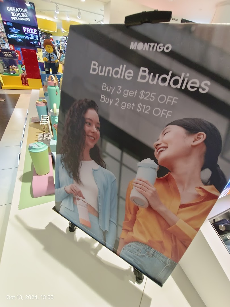 A promotional stand for Montigo's 'Bundle Buddies' offer, featuring water bottles and two models.