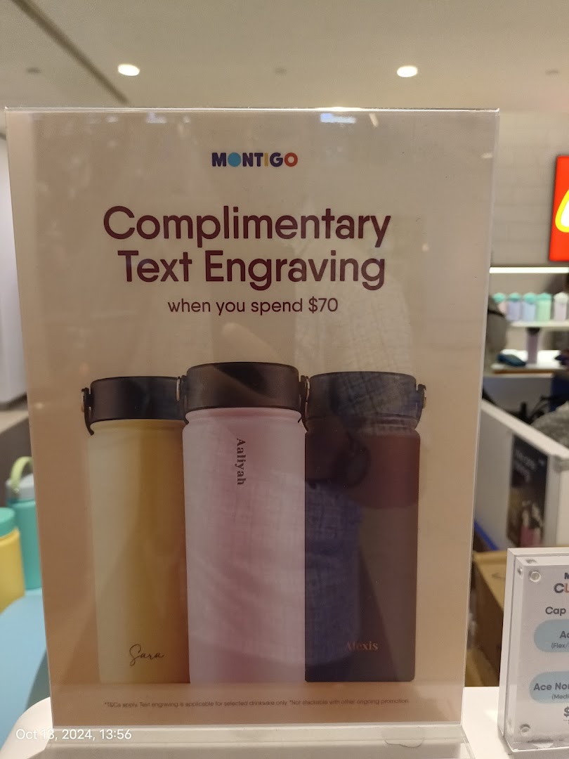 A promotional sign for Montigo offering complimentary text engraving on drinkware with a minimum spend.
