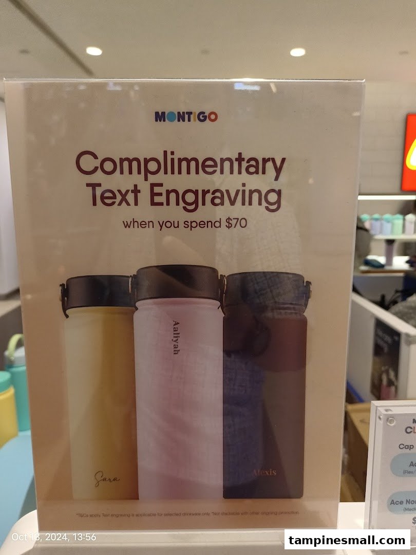 A promotional sign for Montigo offering complimentary text engraving on drinkware with a minimum spend.