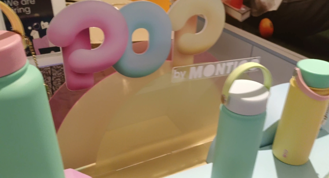 Colorful Montigo water bottles on display with a 'POO by MONTIGO' sign.