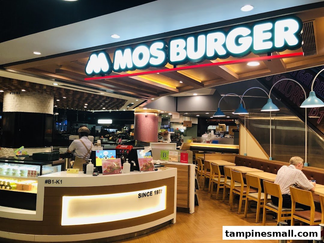 Interior view of MOS Burger showing the service counter, staff, and a spacious dining area.