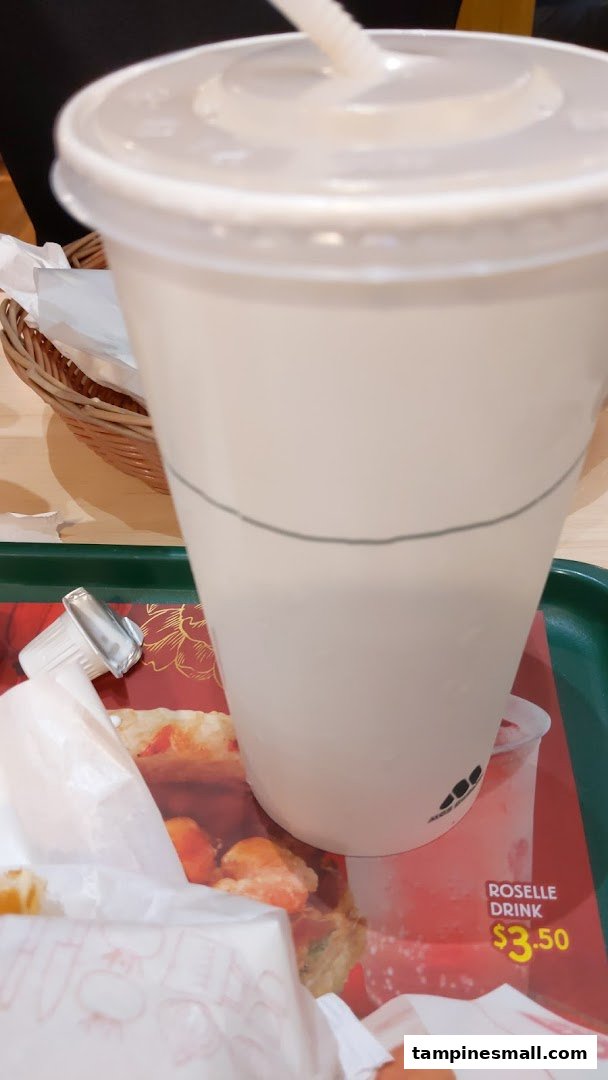 A large drink cup on a tray with food, featuring an advertisement for Roselle Drink.