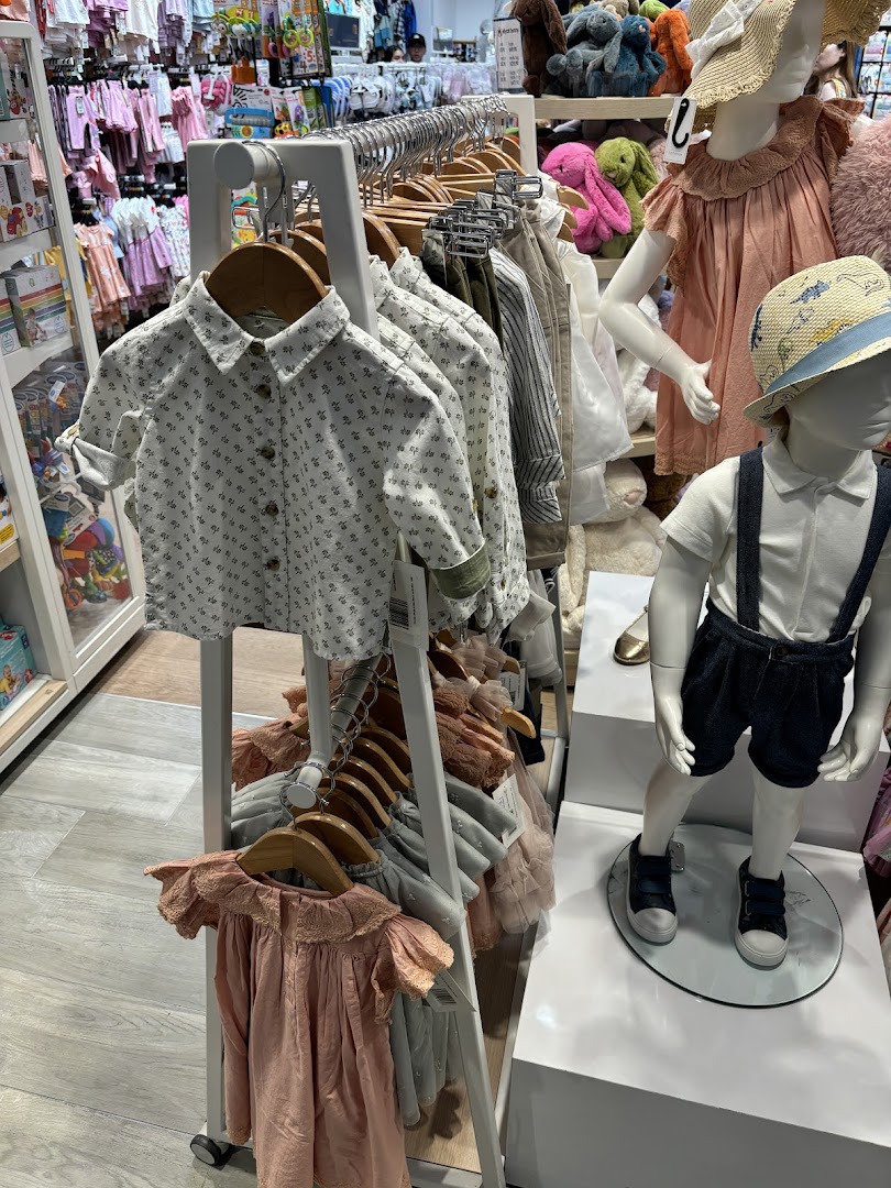 An interior view of Mothercare, showcasing children's clothing on racks and mannequins.