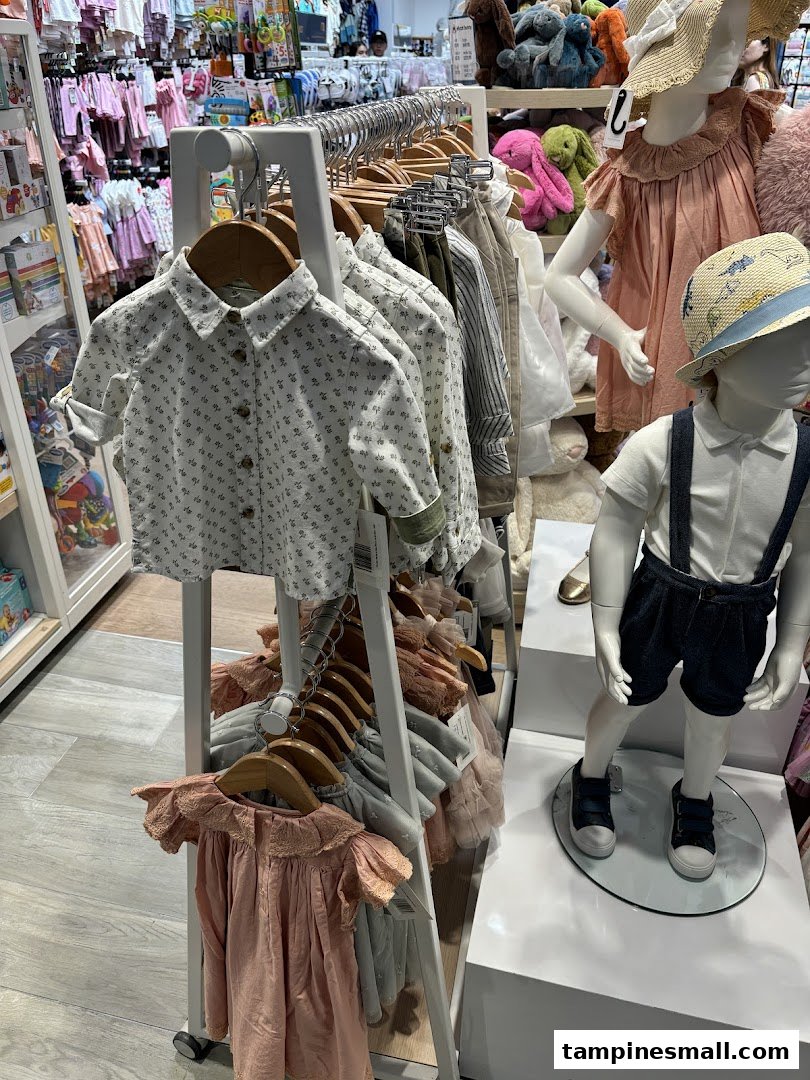 An interior view of Mothercare, showcasing children's clothing on racks and mannequins.
