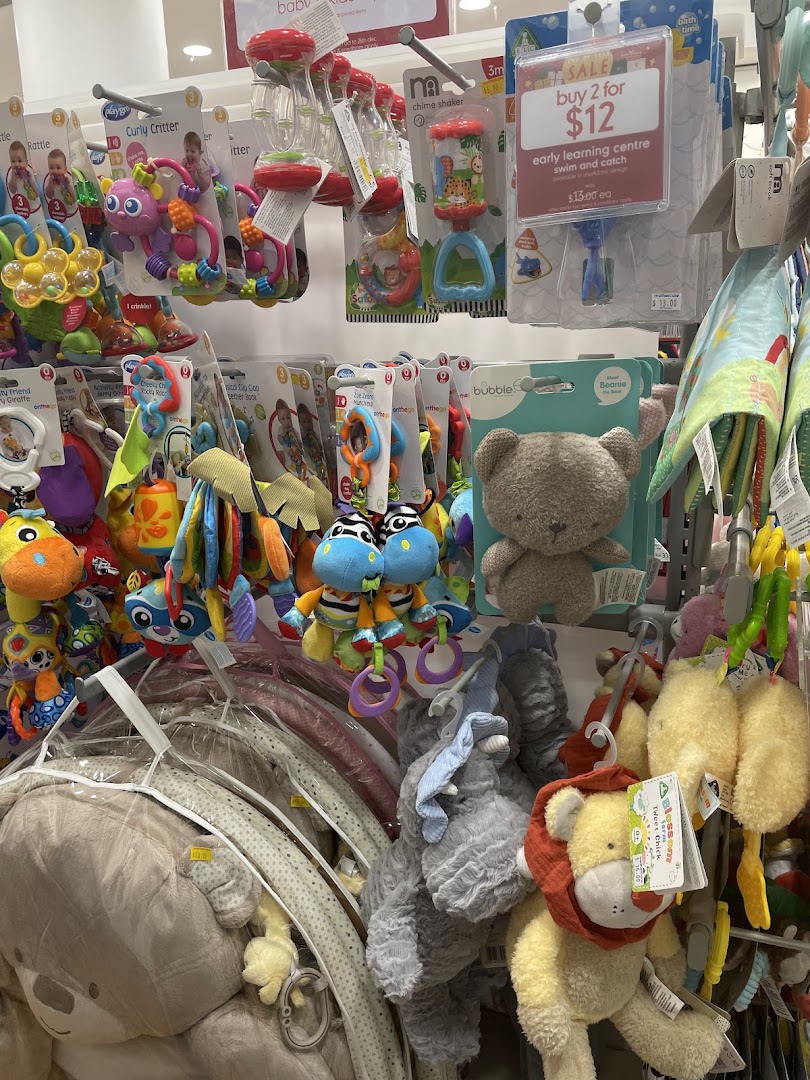 A vibrant display of baby toys, rattles, and plush animals at Mothercare, featuring a 'buy 2 for $12' sale.