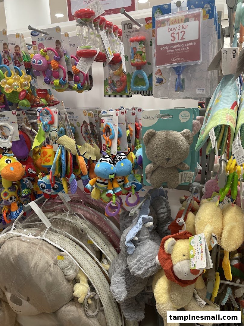 A vibrant display of baby toys, rattles, and plush animals at Mothercare, featuring a 'buy 2 for $12' sale.