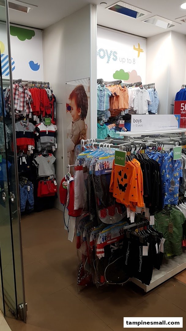 An interior view of Mothercare, showcasing a wide selection of boys' clothing on display racks.