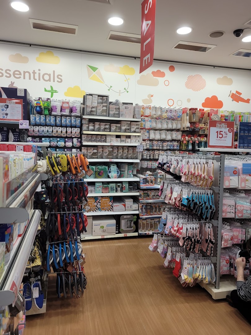 An aisle inside Mothercare, showcasing a wide range of baby essentials, feeding products, and infant clothing.