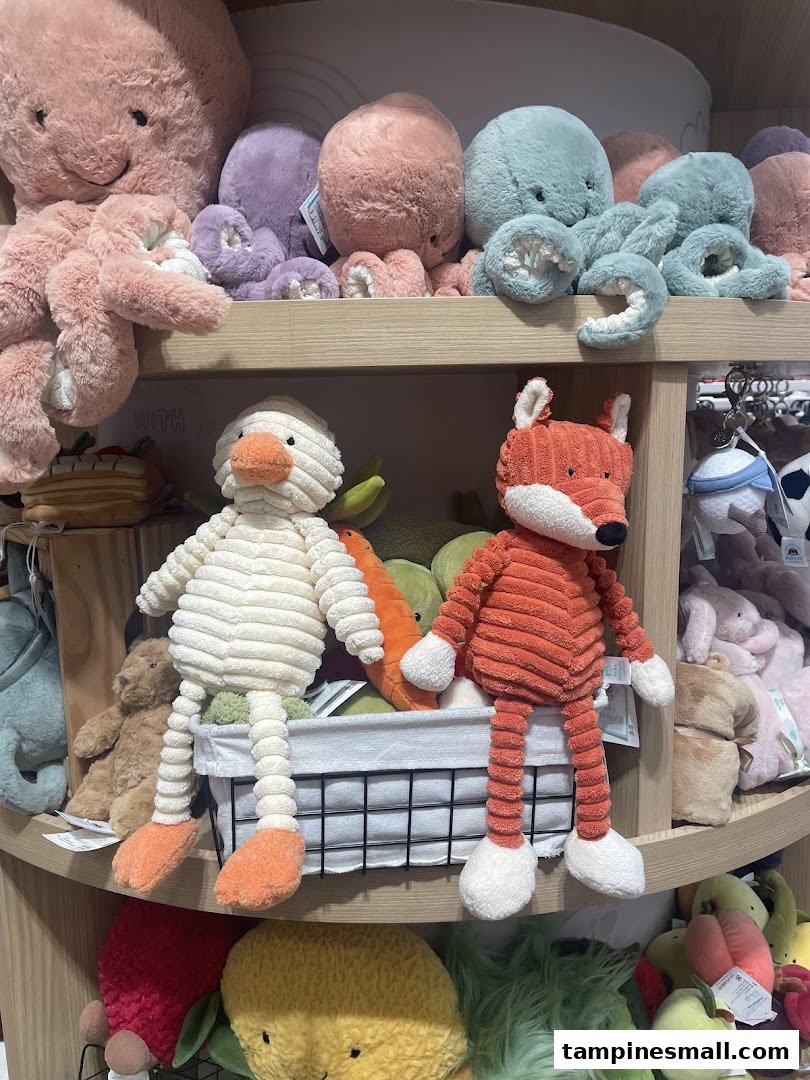 A vibrant display of colorful plush toys, including octopuses, a duck, and a fox, on wooden shelves.