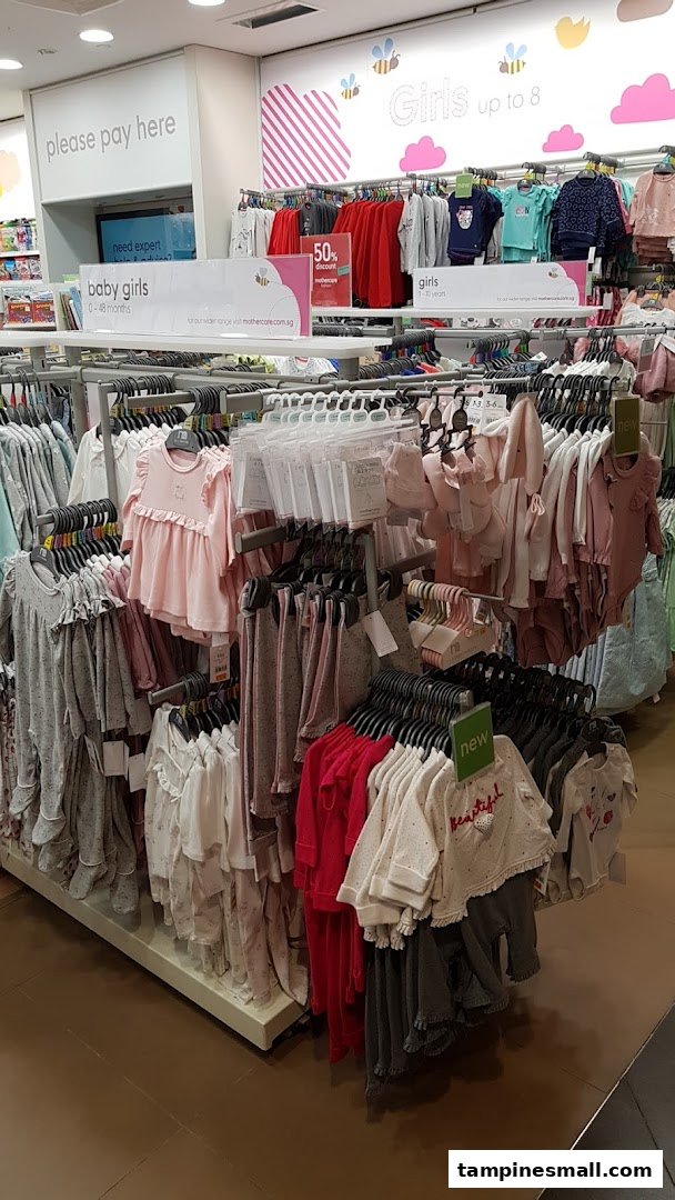 An interior view of Mothercare, showcasing racks of baby and girls' clothing and accessories.