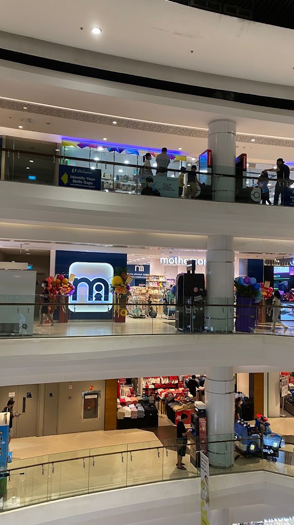 An interior view of a multi-level shopping mall, featuring the Mothercare store on an upper floor.