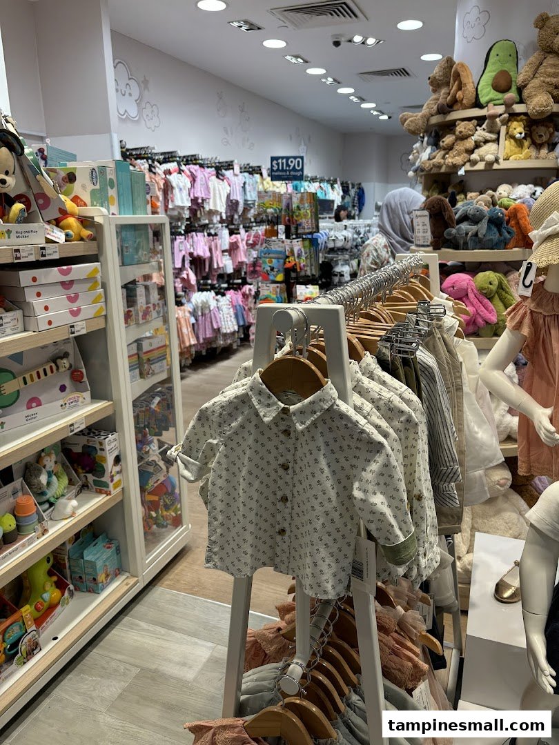 An interior view of Mothercare, showcasing a wide array of baby clothing, toys, and plush animals.