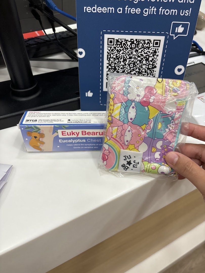 A counter display featuring a QR code for a free gift, Euky Bearu chest rub, and a Ju Ju Be pouch.
