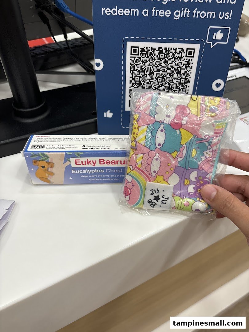 A counter display featuring a QR code for a free gift, Euky Bearu chest rub, and a Ju Ju Be pouch.
