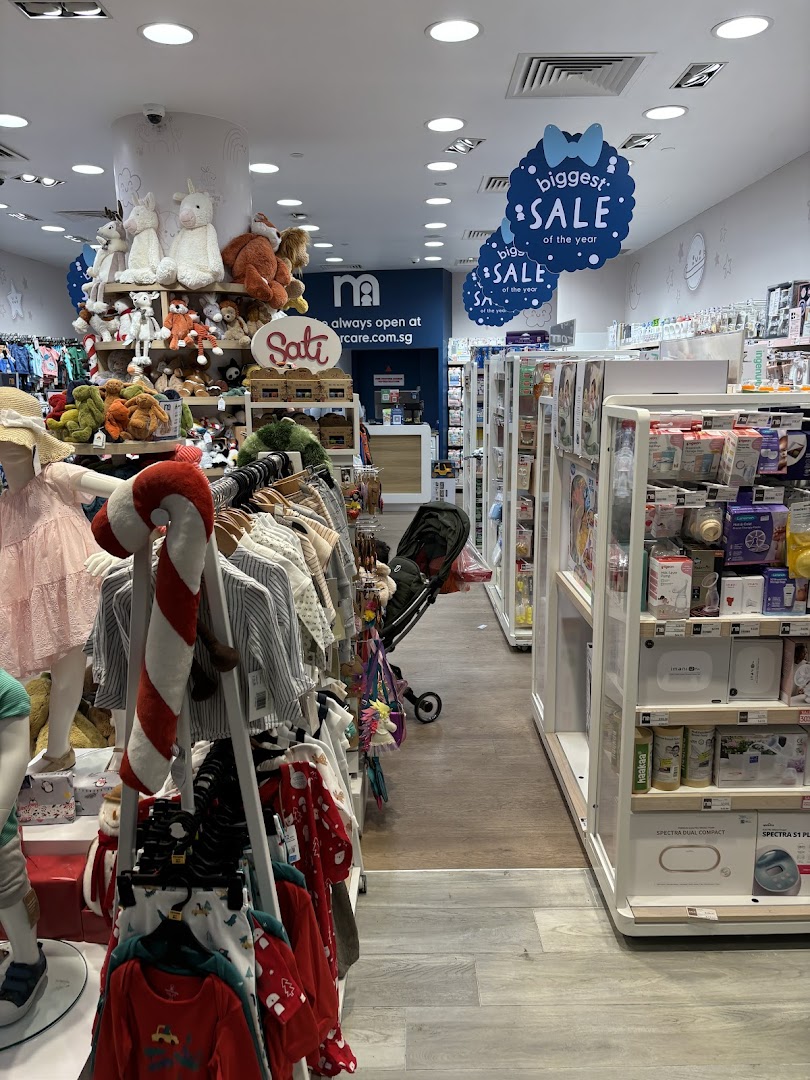 An interior view of Mothercare, showcasing baby clothing, plush toys, and essential baby products, with sale signs visible.