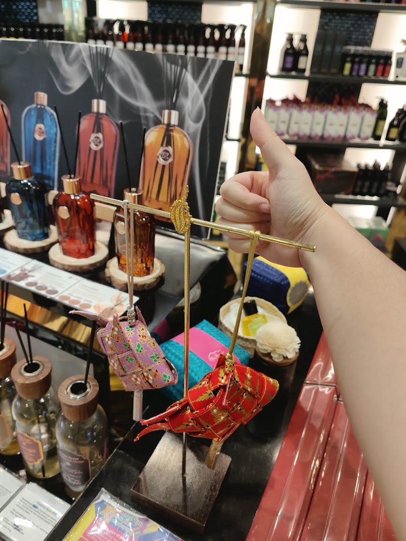 A hand gives a thumbs-up over a display of colorful diffusers and decorative items at Mt.Sapola.