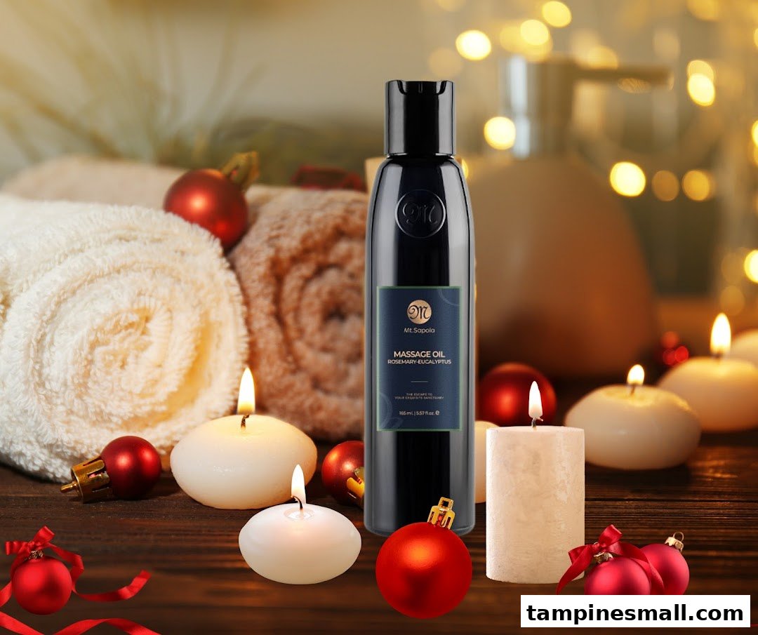 A Mt.Sapola massage oil bottle surrounded by candles, towels, and festive ornaments on a wooden surface.