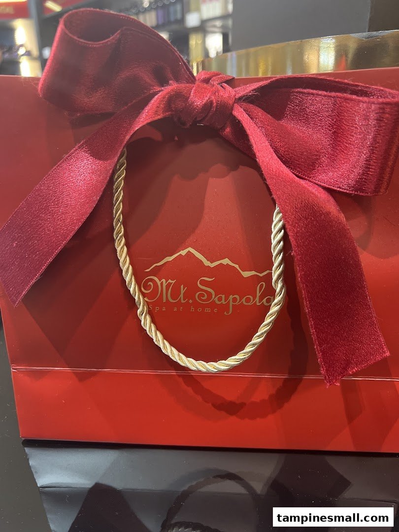 A luxurious red shopping bag with a velvet ribbon and the Mt. Sapola logo.