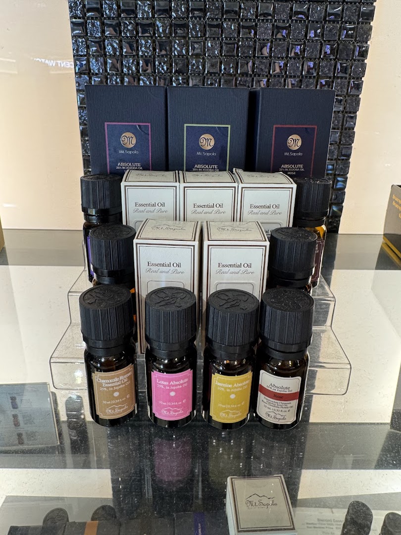 A display of Mt.Sapola essential oils and their packaging on a clear stand.