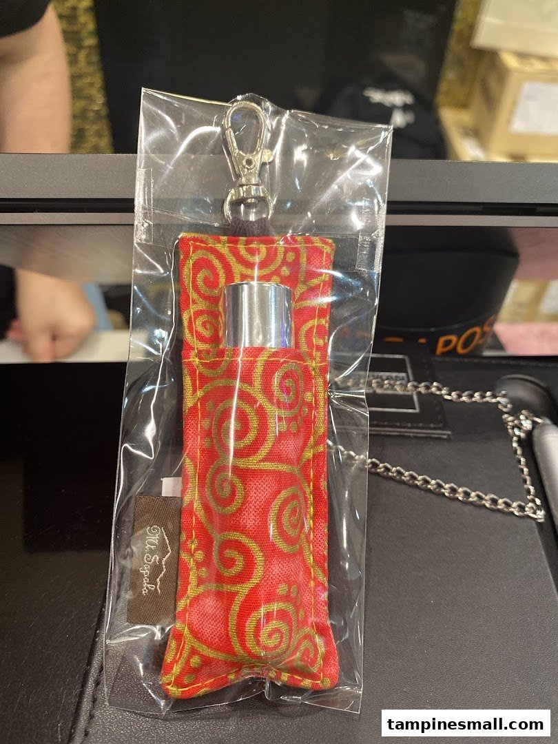 A Mt.Sapola product, likely a rollerball, in a decorative red and gold pouch with a keychain clip.