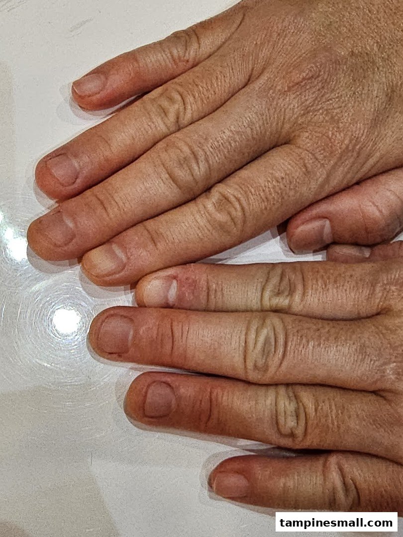 Close-up of hands, likely before a nail treatment, showing natural nails.