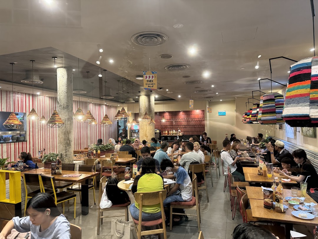 A bustling Nando's restaurant interior filled with customers enjoying their meals in a vibrant setting.