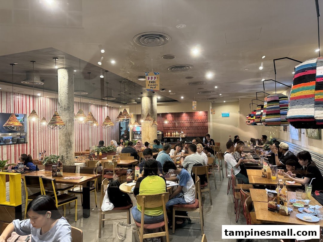 A bustling Nando's restaurant interior filled with customers enjoying their meals in a vibrant setting.