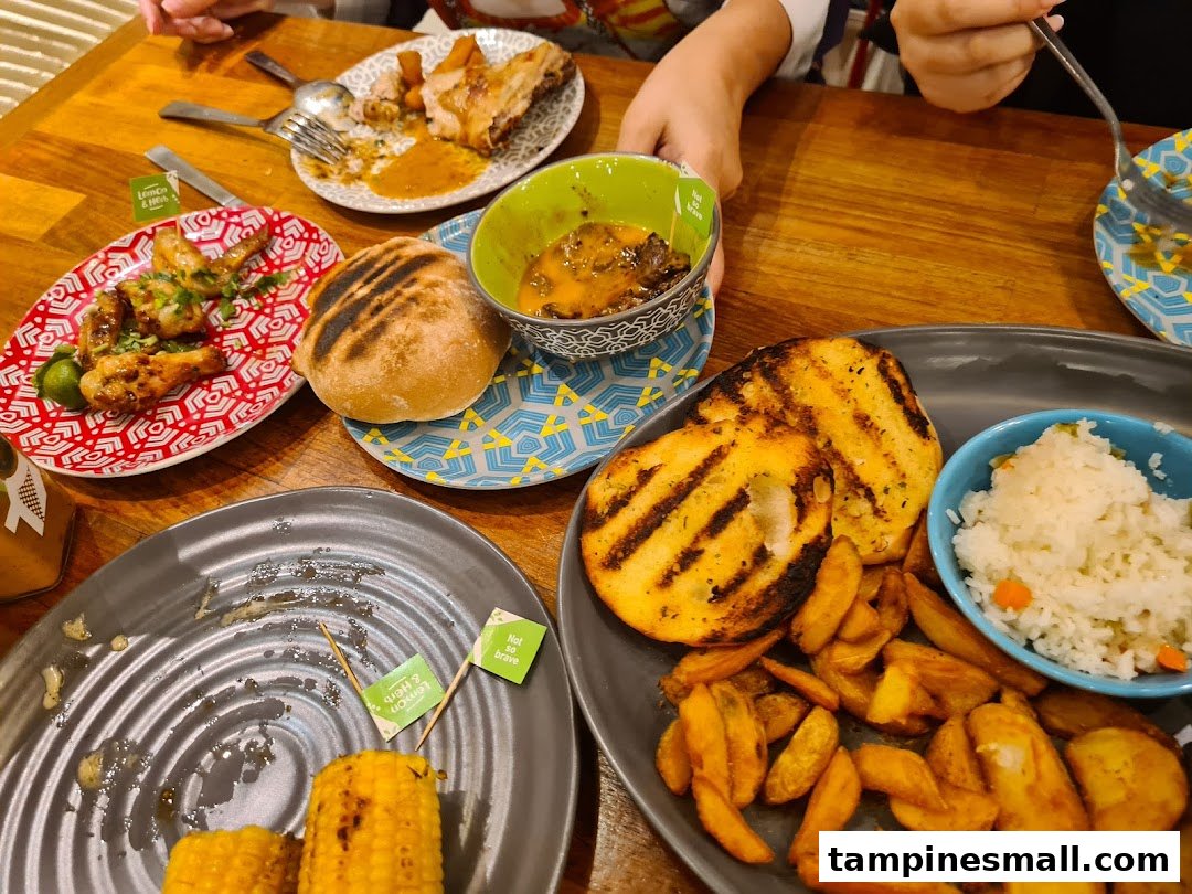 A vibrant table spread at Nando's featuring flame-grilled chicken, various sides, and sauces, enjoyed by diners.