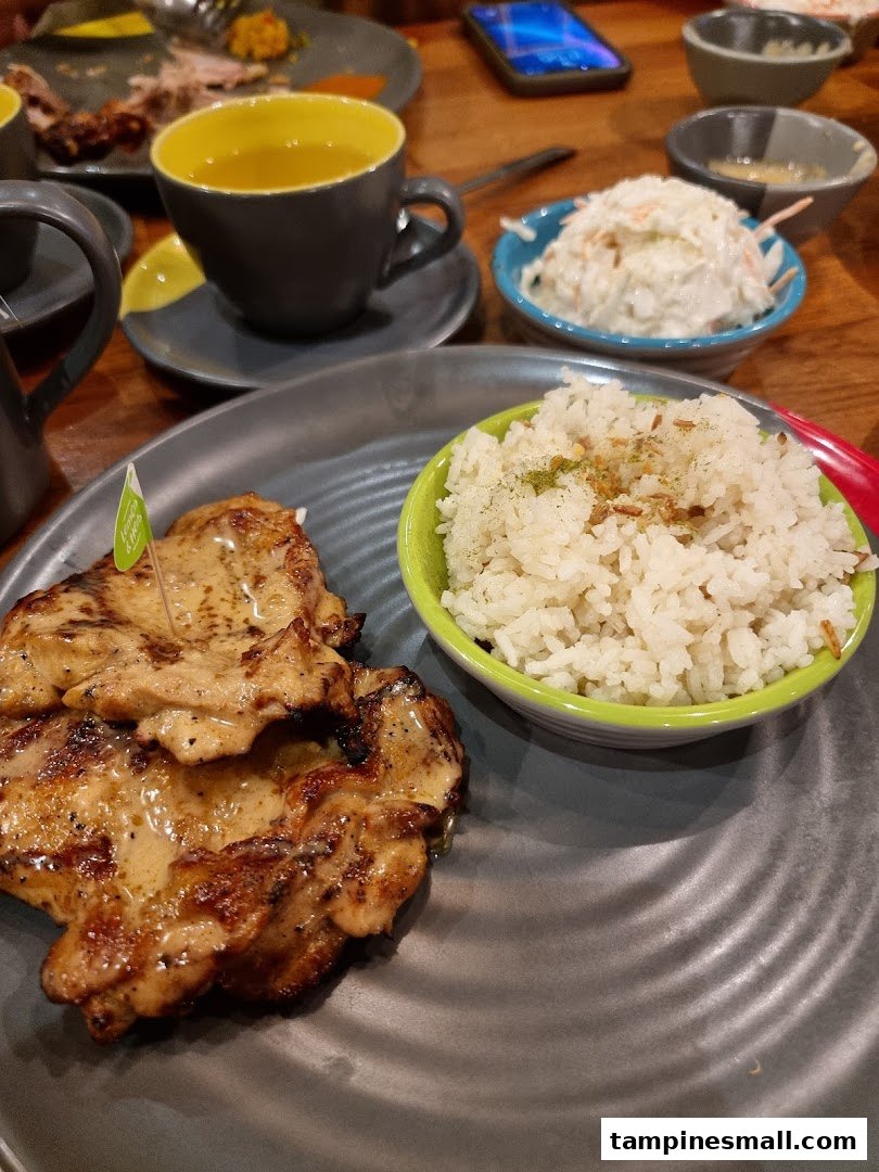 A delicious plate of flame-grilled chicken and rice, served with coleslaw and a drink at Nando's.