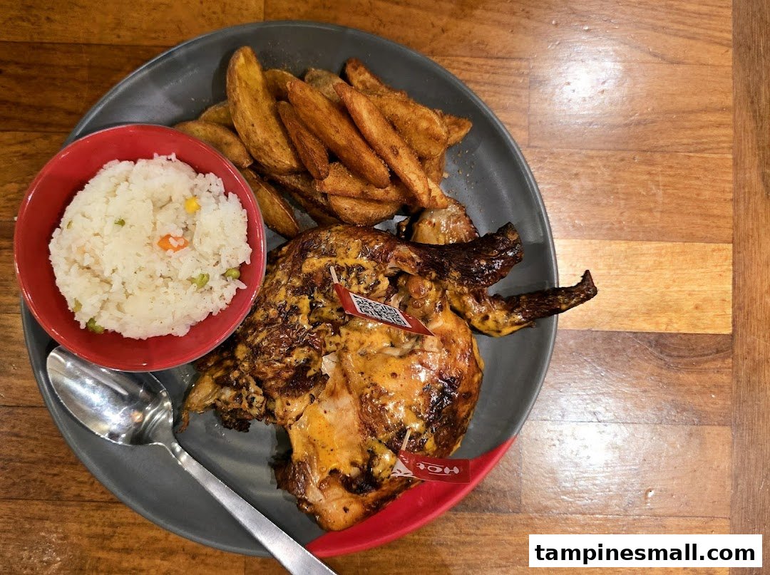 A delicious plate of Nando's flame-grilled PERi-PERi chicken with potato wedges and rice.