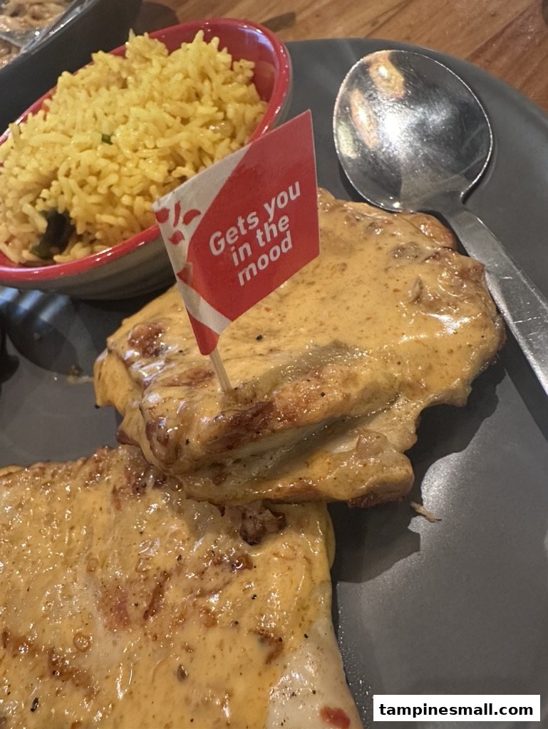 A close-up of Nando's flame-grilled PERi-PERi chicken with creamy sauce, served with yellow rice and a branded flag.