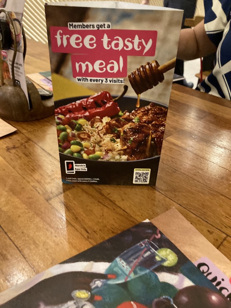 A Nando's table tent promoting a loyalty program for a free meal with every three visits.