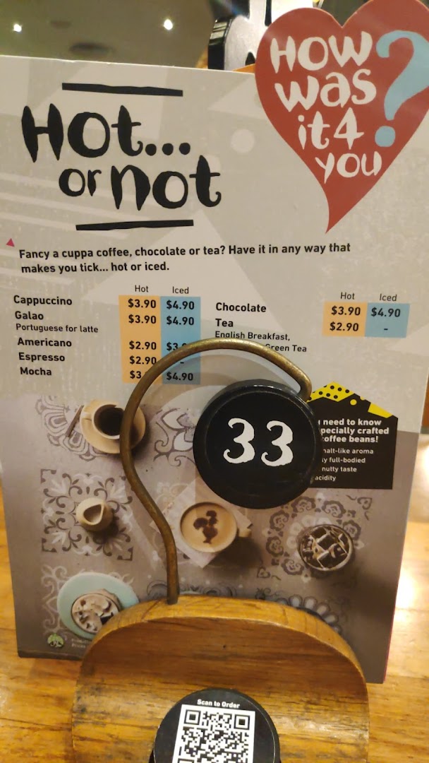 A Nando's table-top menu displaying hot and iced beverage options and prices.