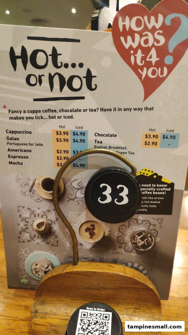A Nando's table-top menu displaying hot and iced beverage options and prices.