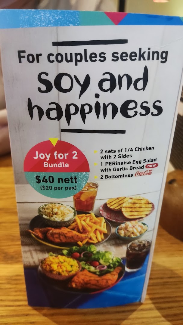 A Nando's menu board advertising a 'Joy for 2 Bundle' with chicken, sides, and drinks.