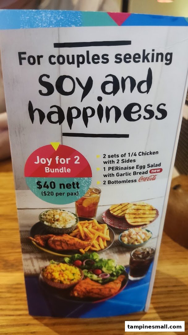 A Nando's menu board advertising a 'Joy for 2 Bundle' with chicken, sides, and drinks.