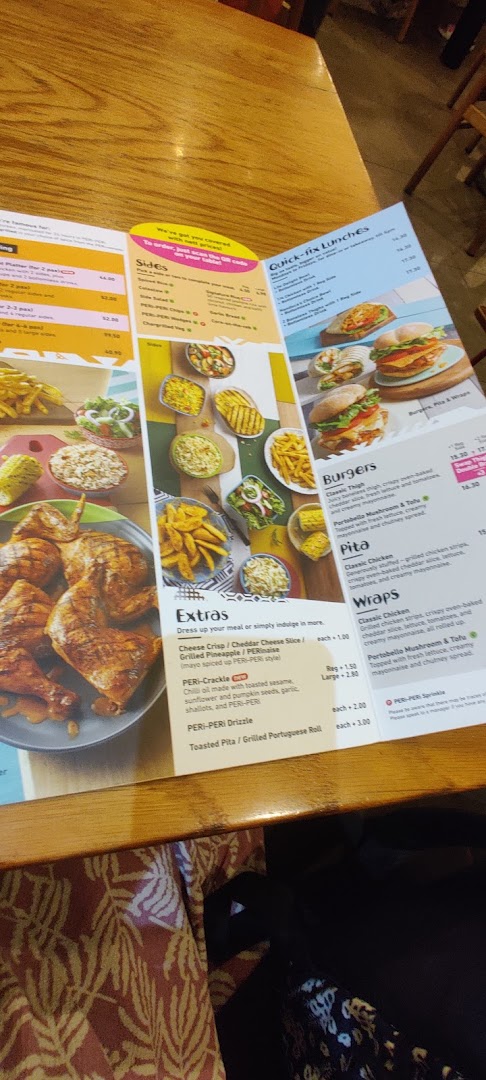 A detailed view of the Nando's menu, showcasing various chicken dishes, sides, burgers, and wraps.